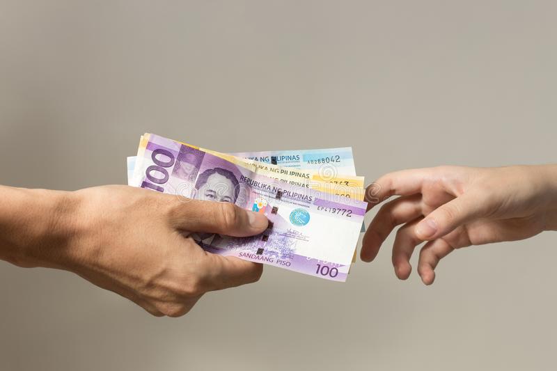 hand-holding-giving-cash-banknotes-philippines-peso-paying-bills-payment-procedure-bribe-salary-hand-holding-giving-cash-165107135